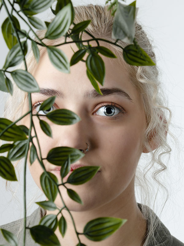 A portrait of a blonde-haired woman with plants 