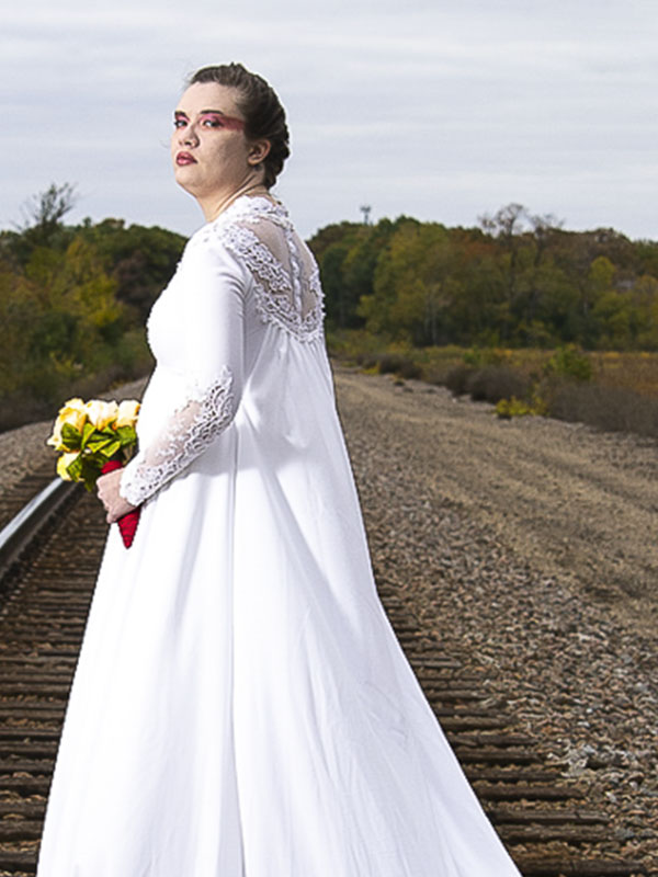 woman in wedding dress
standing on railroad