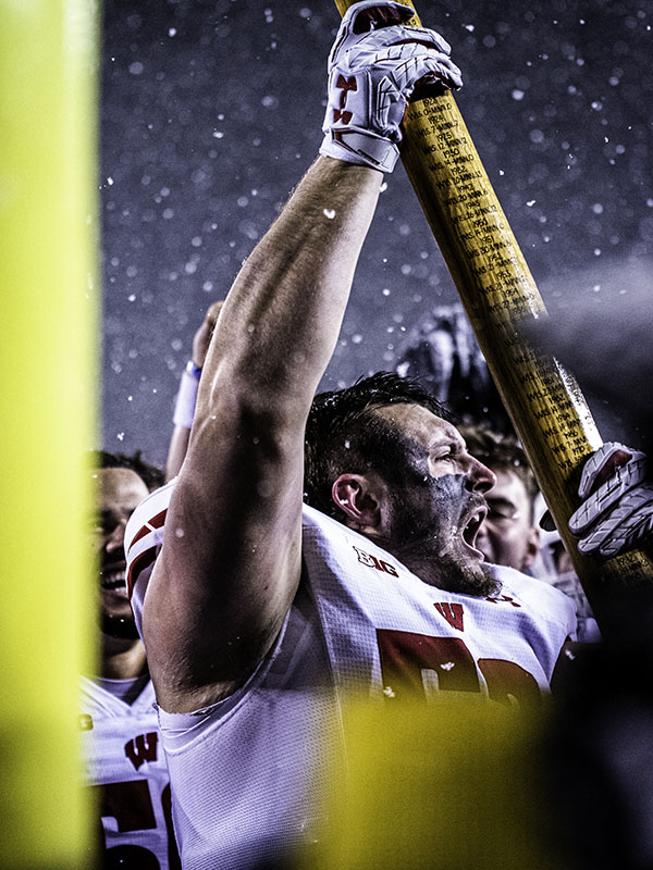 wisconsin badges player celebrates in the falling
                                                            snow after defeating the gophers for the battle of
                                                            paul bunyan's axe