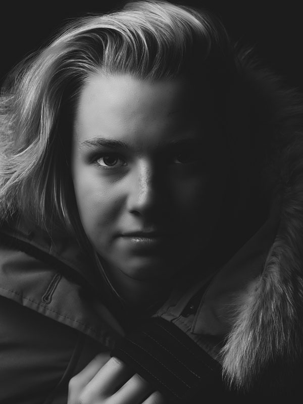 Woman in winter coat with dramatic lighting